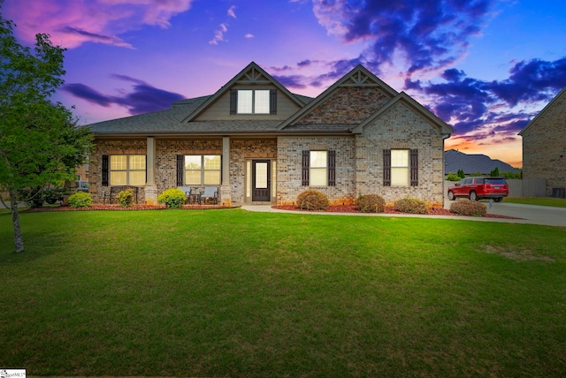 craftsman-style home featuring a porch, brick siding, and a front lawn