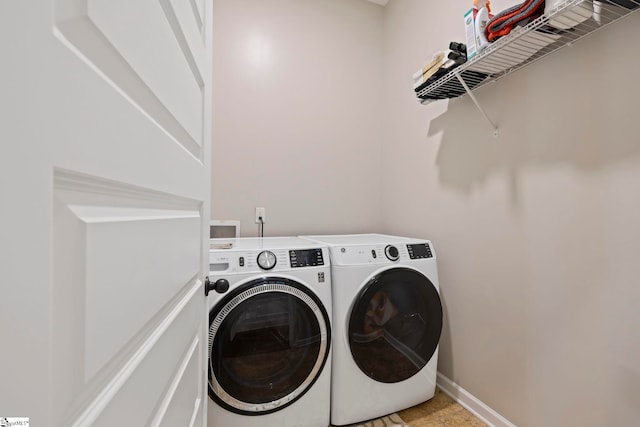 laundry room featuring washing machine and clothes dryer, laundry area, and baseboards
