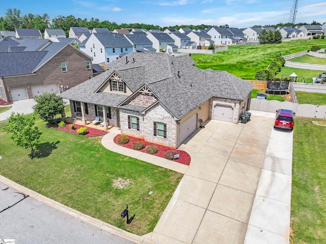 view of front of home with fence, roof with shingles, an attached garage, stone siding, and concrete driveway