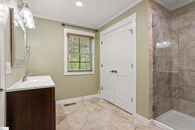 bathroom with crown molding, vanity, baseboards, a shower stall, and visible vents