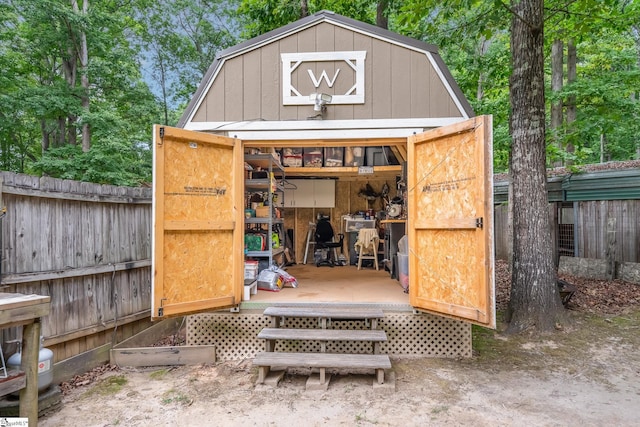 view of outbuilding with fence and an outbuilding