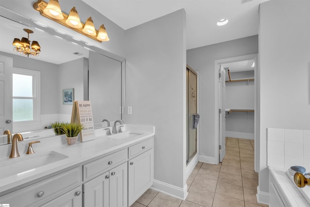 full bath featuring an inviting chandelier, a sink, tile patterned floors, and a shower stall