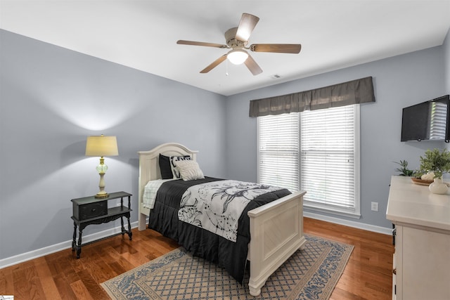 bedroom with baseboards, ceiling fan, wood finished floors, and visible vents