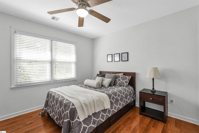 bedroom with visible vents, baseboards, ceiling fan, and wood finished floors