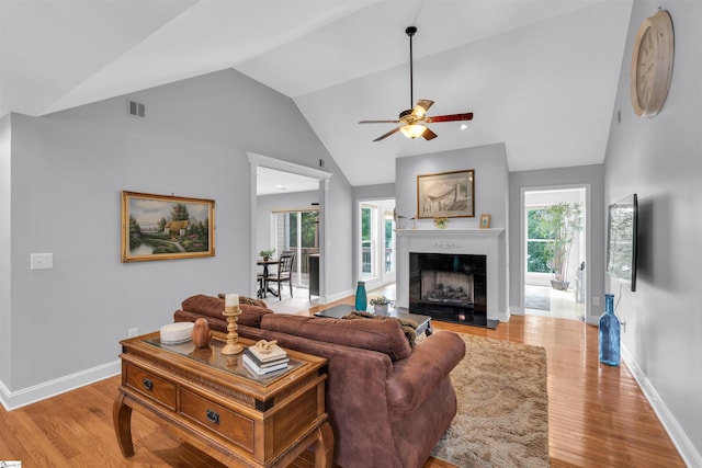 living area featuring a ceiling fan, baseboards, vaulted ceiling, and visible vents