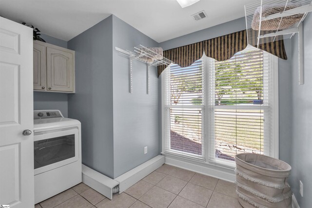 laundry room with visible vents, cabinet space, light tile patterned floors, baseboards, and washer / dryer