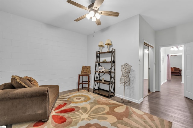 sitting room featuring baseboards, a ceiling fan, and wood finished floors