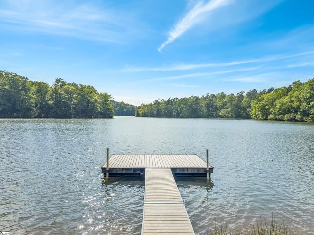 dock area with a view of trees and a water view