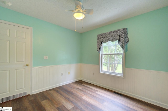 602 Habersham Ln, Easley, SC 29642 - empty room featuring visible vents, a ceiling fan, a wainscoted wall, and wood finished floors