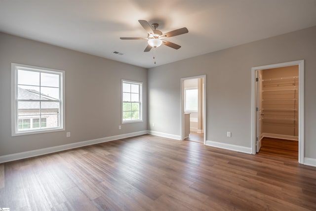 241 Carriage Gate Dr, Wellford, SC 29385 - unfurnished bedroom featuring a walk in closet, a ceiling fan, visible vents, wood finished floors, and baseboards