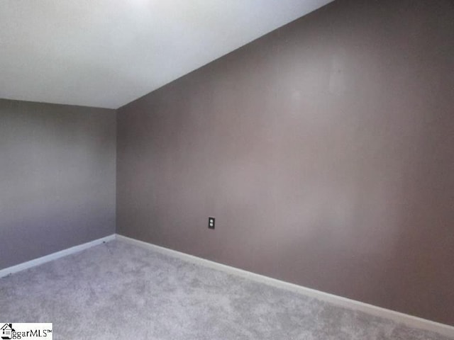 unfurnished room featuring baseboards and carpet