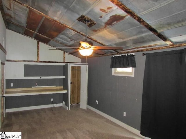 below grade area with carpet floors and ceiling fan
