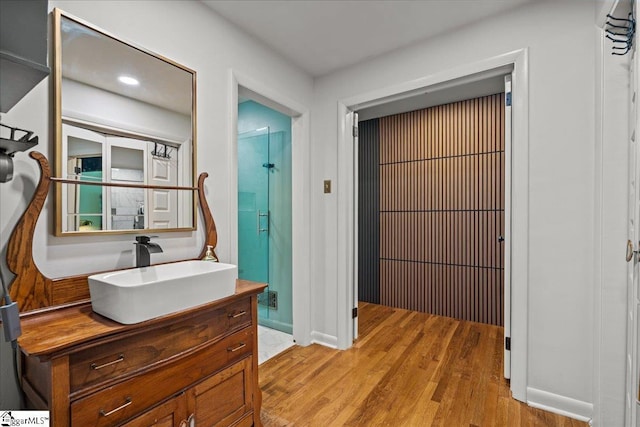 bathroom featuring vanity, baseboards, and wood finished floors