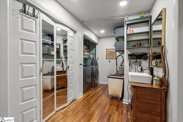 walk in closet featuring a sink, washer and clothes dryer, and wood finished floors