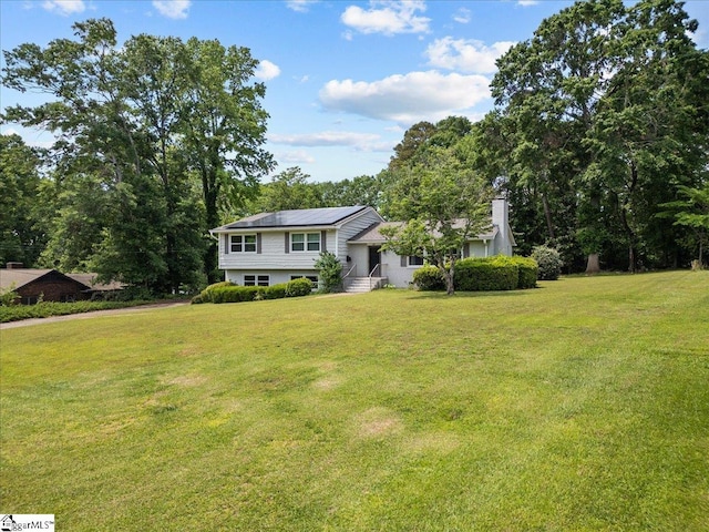 view of front of home featuring a chimney and a front yard