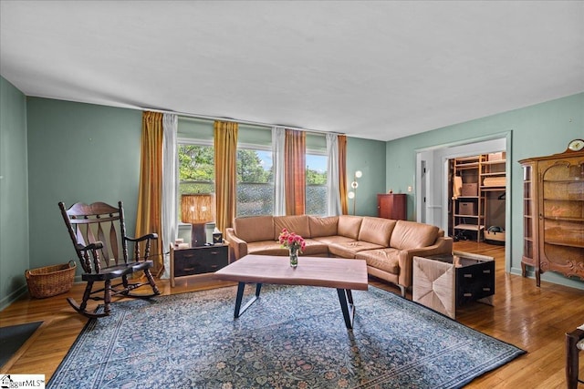 living area featuring baseboards and wood finished floors