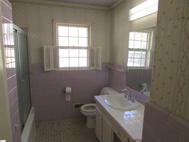 bathroom featuring vanity, toilet, a wainscoted wall, tile walls, and visible vents