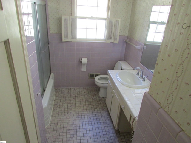 full bath with visible vents, wainscoting, toilet, and wallpapered walls