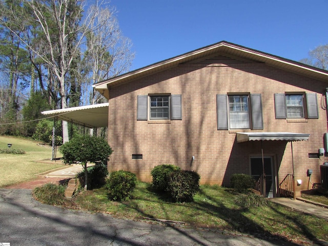 view of property exterior featuring a yard and brick siding