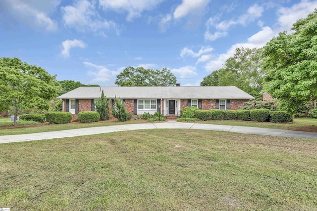 ranch-style house with brick siding, a front lawn, and curved driveway