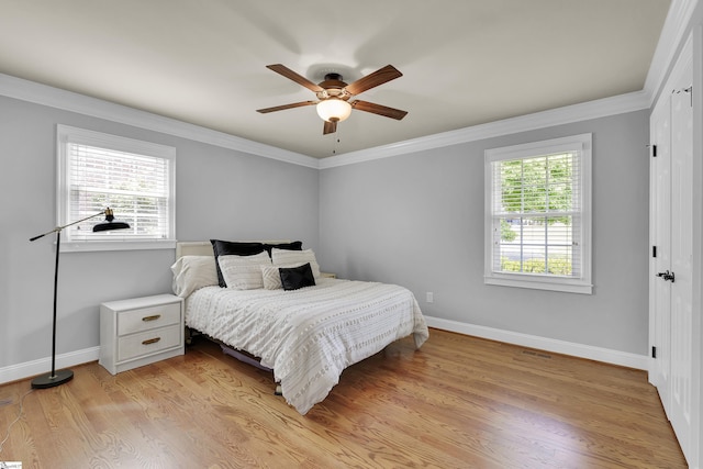 bedroom featuring baseboards, ornamental molding, and multiple windows