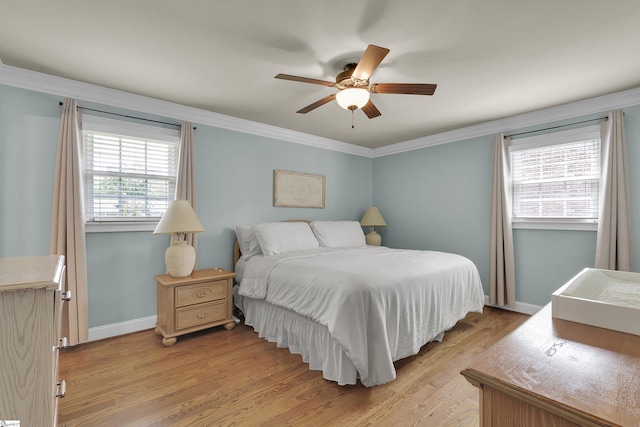 bedroom with crown molding, baseboards, and light wood-style flooring