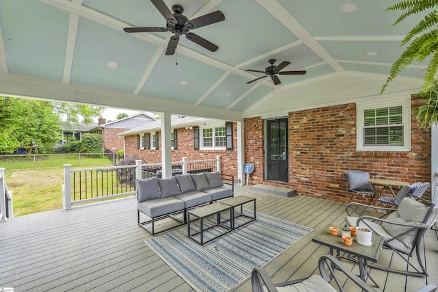 wooden deck with an outdoor hangout area, a ceiling fan, a yard, and fence