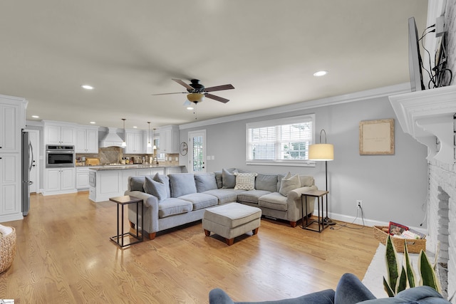 living area with crown molding, recessed lighting, and a ceiling fan