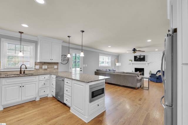 kitchen featuring crown molding, a sink, white cabinetry, and appliances with stainless steel finishes
