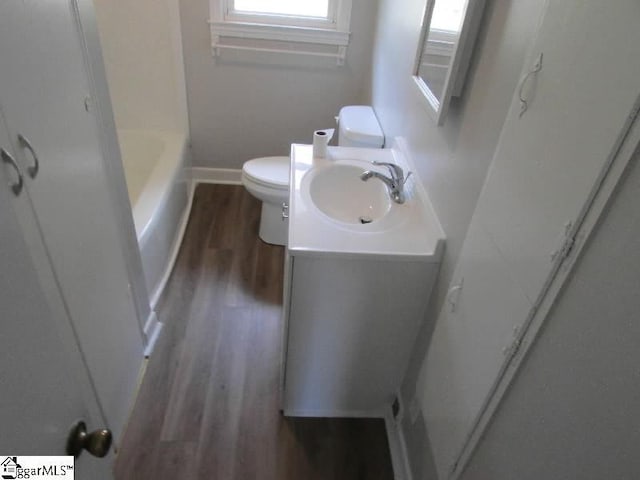full bathroom with vanity, toilet, baseboards, wood finished floors, and a shower