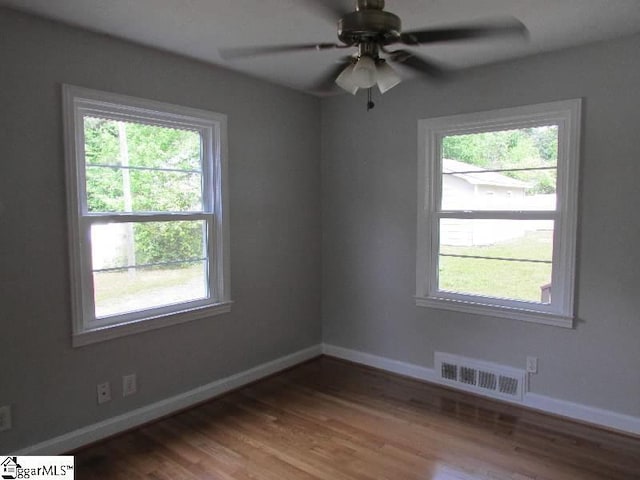 spare room with visible vents, baseboards, ceiling fan, and wood finished floors