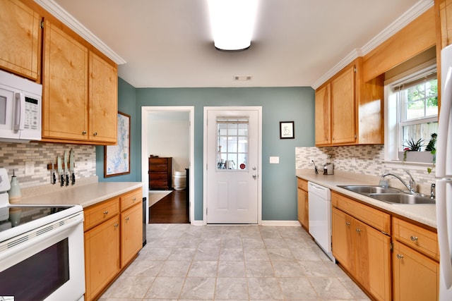 kitchen with white appliances, backsplash, a sink, and light countertops