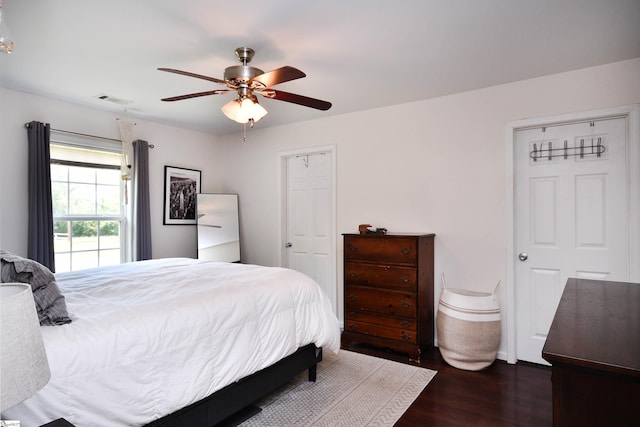 bedroom with visible vents, baseboards, ceiling fan, and wood finished floors