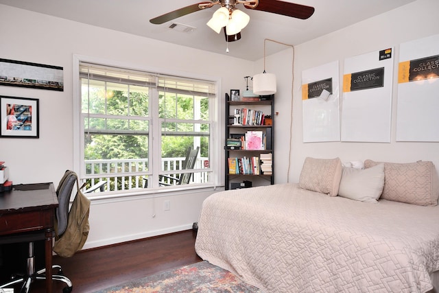 bedroom with visible vents, a ceiling fan, baseboards, and wood finished floors