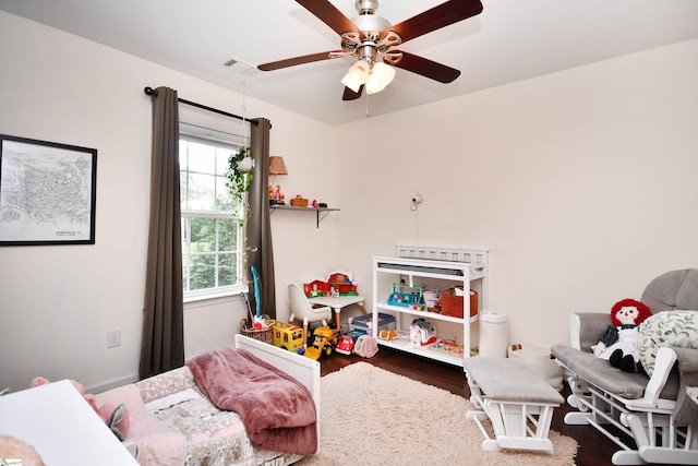 bedroom with ceiling fan, visible vents, and wood finished floors