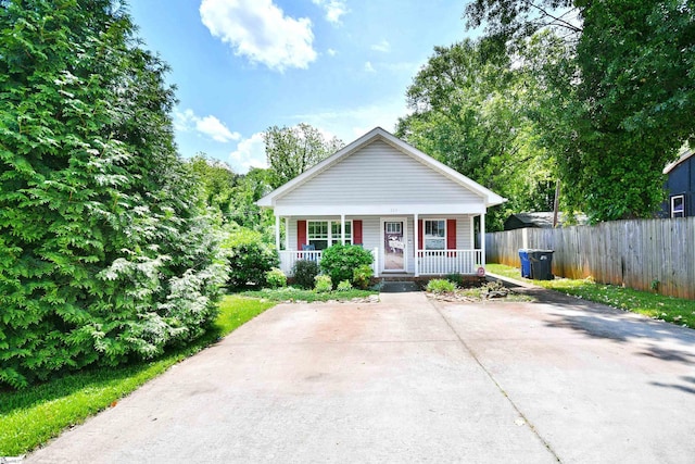 bungalow featuring a porch and fence
