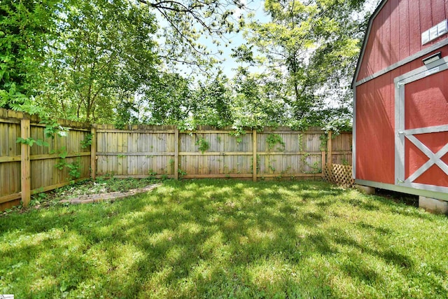 view of yard featuring an outdoor structure, a fenced backyard, and a storage shed