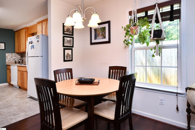 dining room featuring baseboards, light wood finished floors, and a chandelier