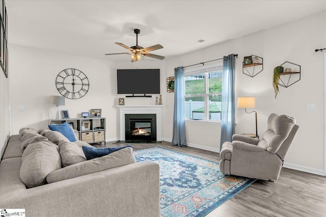 75 Oak Edge Ln, Greer, SC 29651 - living area featuring a glass covered fireplace, baseboards, ceiling fan, and wood finished floors