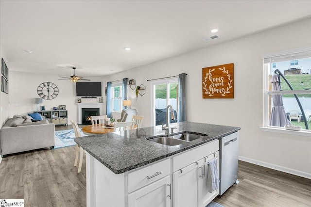 75 Oak Edge Ln, Greer, SC 29651 - kitchen featuring a warm lit fireplace, a sink, dishwasher, an island with sink, and a ceiling fan