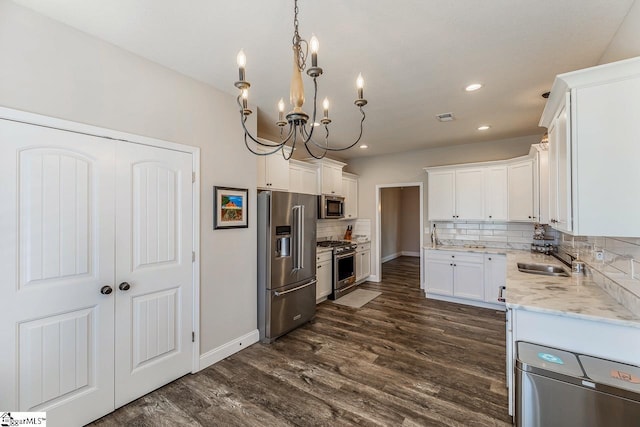 kitchen featuring recessed lighting, a sink, backsplash, a notable chandelier, and stainless steel appliances