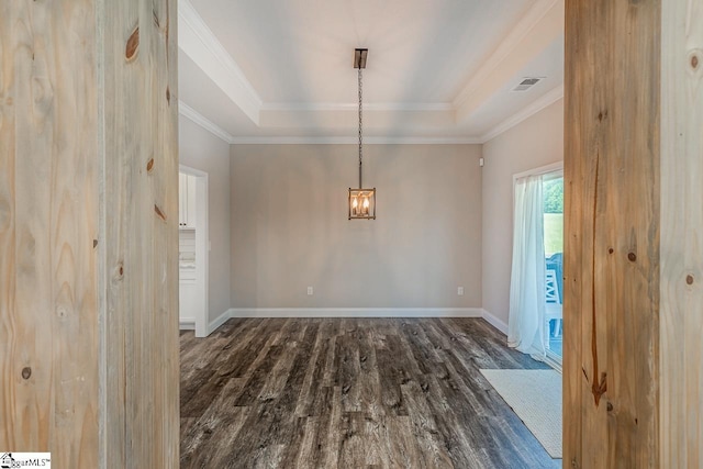 unfurnished dining area featuring crown molding, a raised ceiling, dark wood finished floors, and visible vents