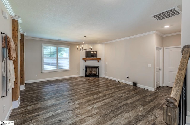 unfurnished living room with visible vents, dark wood finished floors, crown molding, and a notable chandelier