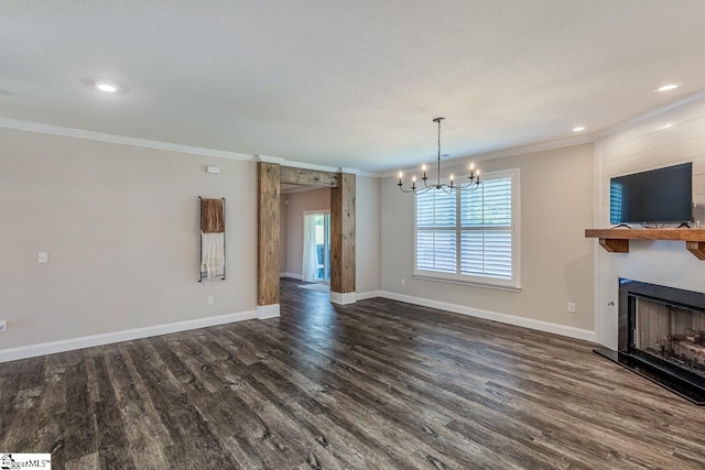 unfurnished living room featuring crown molding, a fireplace, baseboards, a chandelier, and dark wood-type flooring