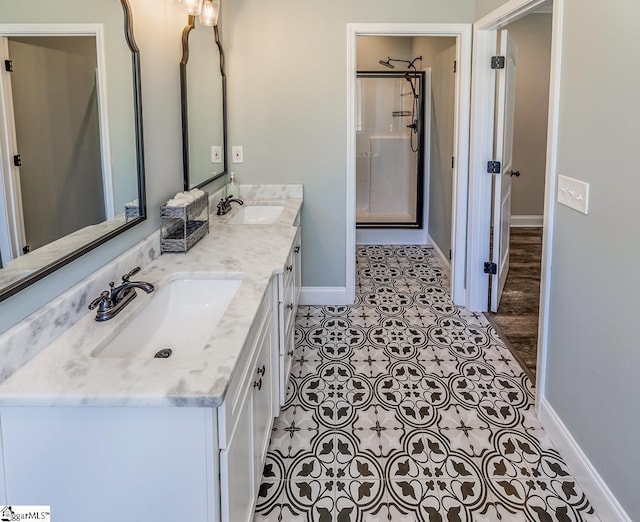 full bathroom with baseboards, a shower stall, a sink, and tile patterned floors