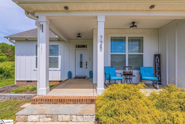 doorway to property with roof with shingles, covered porch, and board and batten siding