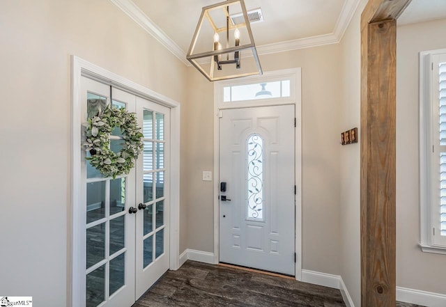 foyer with french doors, baseboards, crown molding, and a chandelier