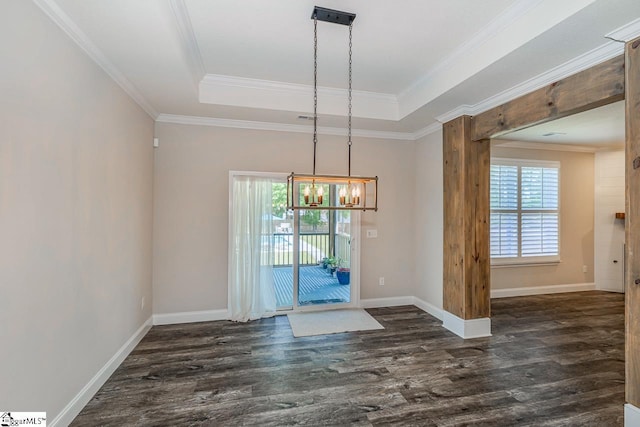unfurnished dining area with ornamental molding, baseboards, a raised ceiling, dark wood finished floors, and a notable chandelier