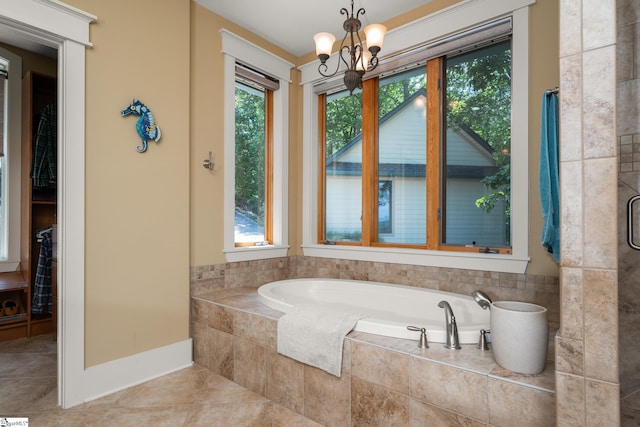 full bath featuring a garden tub, baseboards, an enclosed shower, tile patterned floors, and a notable chandelier