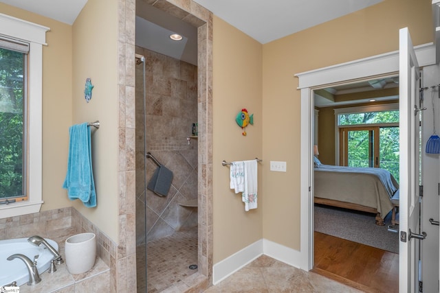 ensuite bathroom featuring wood finished floors, a shower stall, a bath, and connected bathroom